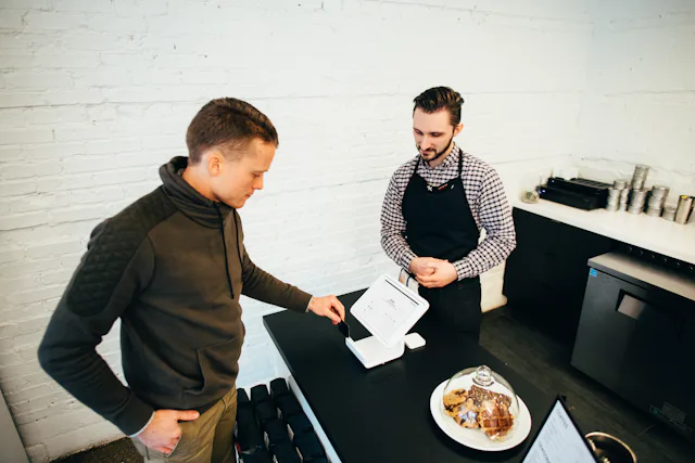 A server taking payment from a guest at the counter
