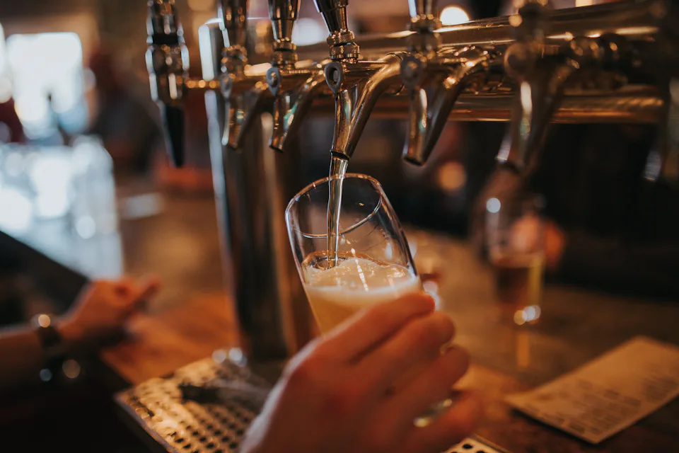 A pint being poured at a pub bar