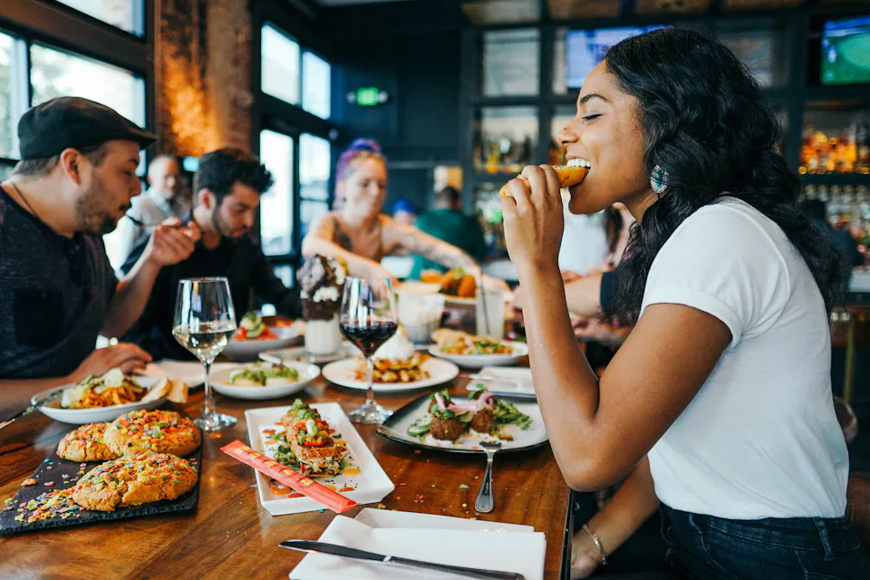 Friends sharing dinner at a busy restaurant table
