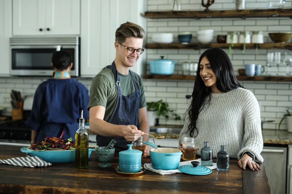 Two people cooking together in a bright kitchen