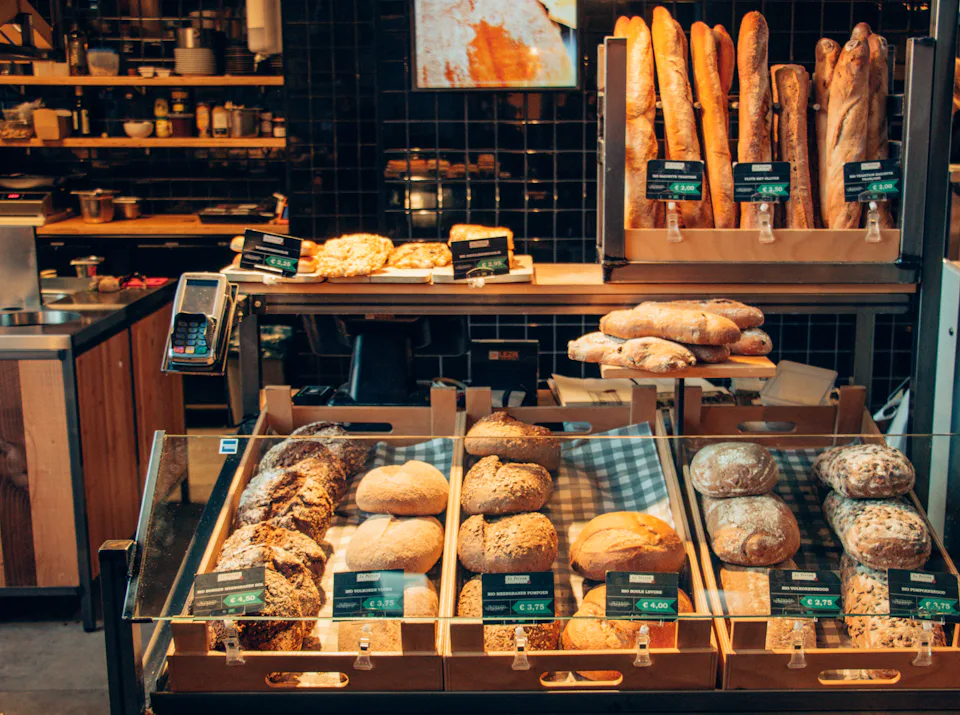 A bakery counter stacked with labelled loaves and pastries