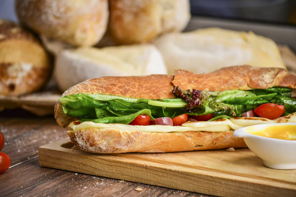 A filled baguette on a wooden board