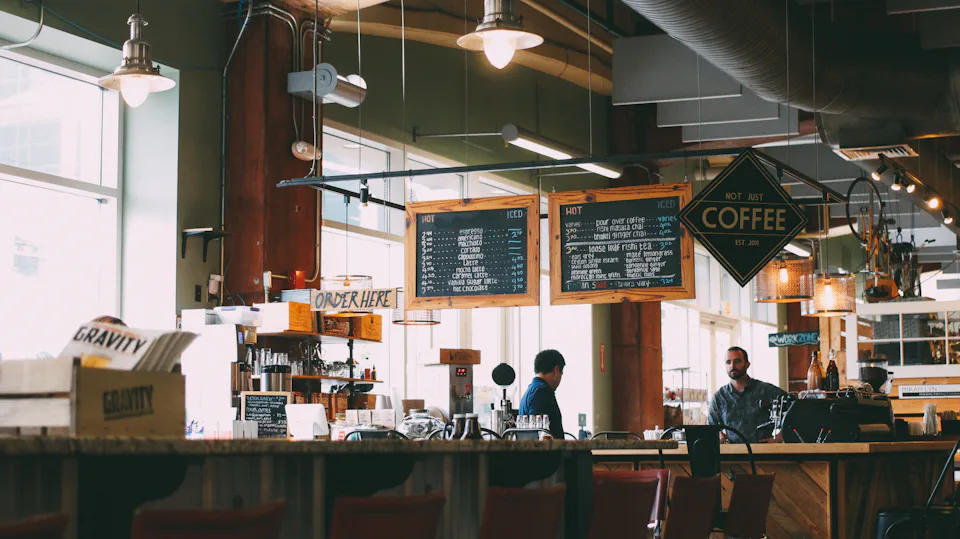 A café counter with coffee menu boards