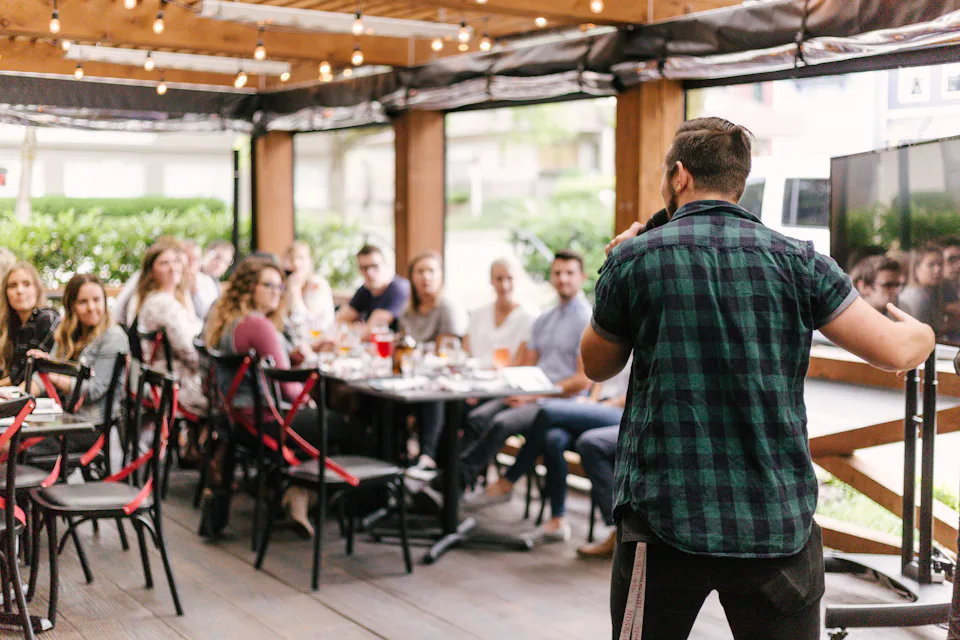 A host speaking to a room of guests